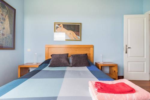 a bedroom with a blue bed with a red blanket at Spacious house with sea view in Liencres + jacuzzi in Liencres