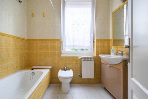 a bathroom with a tub and a toilet and a sink at Spacious house with sea view in Liencres + jacuzzi in Liencres