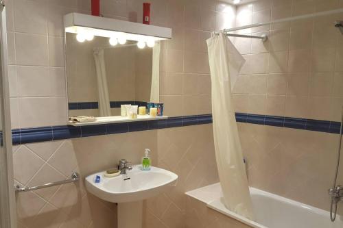 a bathroom with a sink and a shower and a mirror at Spacious house with sea view in Liencres + jacuzzi in Liencres