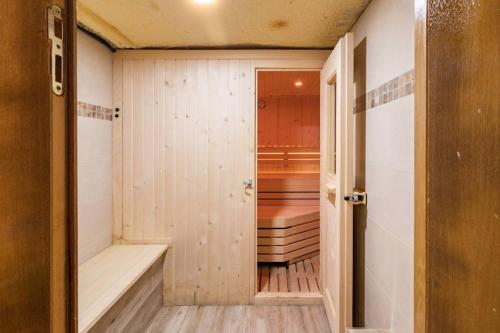 a sauna with wood paneling and a door leading into a room at Spacious house with sea view in Liencres + jacuzzi in Liencres