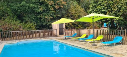 - un groupe de chaises longues et de parasols à côté de la piscine dans l'établissement Rivière Retreat, à Bergerac