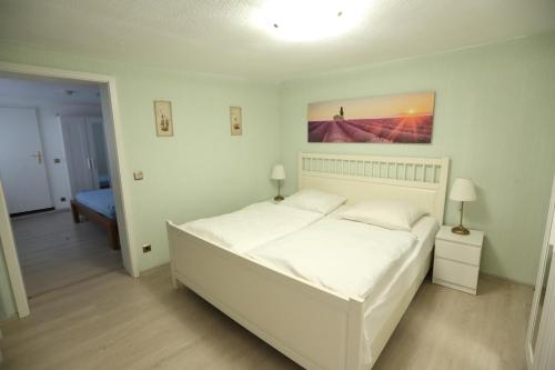 Un dormitorio con una gran cama blanca en una habitación. en City Wohnung 12 B, en Brühl
