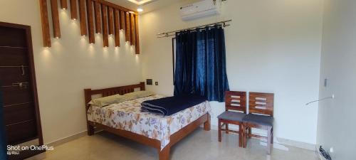 a bedroom with a bed and a chair and a window at Archana palace hampi in Hampi
