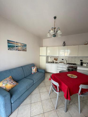 a living room with a blue couch and a table at Appartamento ' Il sole di Vale' in Loano