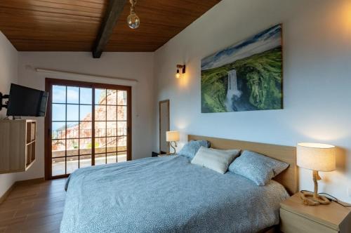 a bedroom with a bed and a large window at Arico Cave Experience in Arico