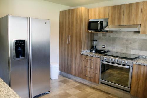 a kitchen with a stainless steel refrigerator and a microwave at Hotel Boutique La Rioja in Atlixco