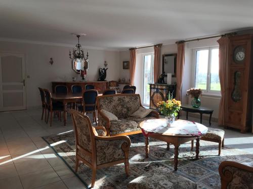 un salon avec un canapé, une table et des chaises dans l'établissement Charmante maison avec piscine, à Saint-Marc-sur-Couesnon