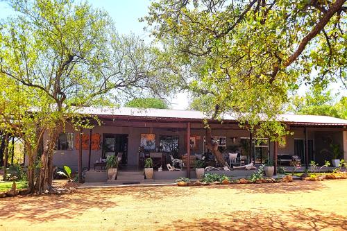 a house with a porch with couches and trees at Ngalali Retreat in Grietjie Nature Reserve
