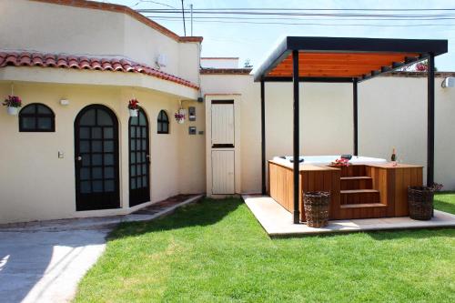 a hot tub in a yard next to a house at Hotel Boutique La Rioja in Atlixco