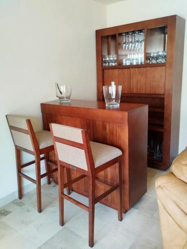 a wooden bar with two chairs and a table at Hotel Boutique La Rioja in Atlixco