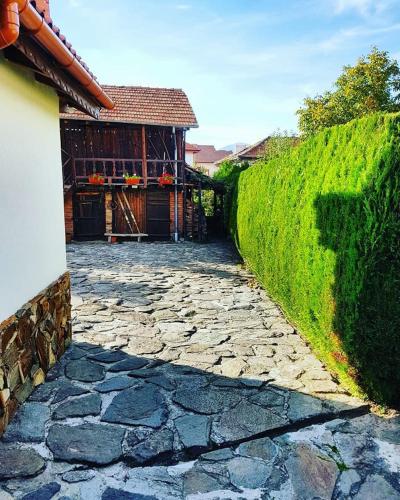 a stone walkway next to a building with a hedge at Villa Leventy in Banya