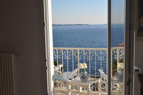 a balcony with a table and chairs and the ocean at Apartment La Rosa in Gardone Riviera