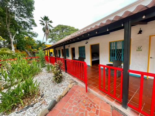a house with a red fence in front of it at Restaurante - Hotel Los Manguitos in Rivera