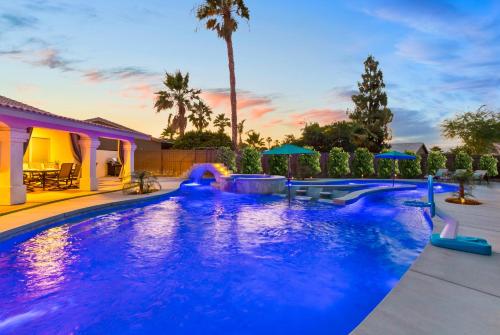 a large swimming pool with blue lighting in a backyard at LAZY RIVER POOL , Water slide, Kids outdoor play area, Arcade games in Coachella