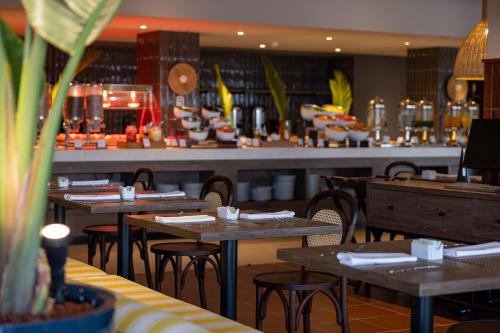 a restaurant with tables and chairs and a bar at Aranwa Paracas Resort & Spa in Paracas
