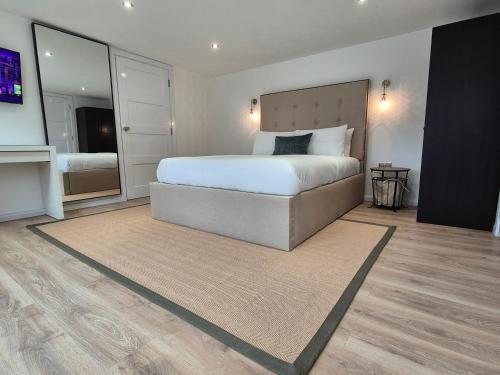 a bedroom with a large bed and a large mirror at Hotel CG London in London