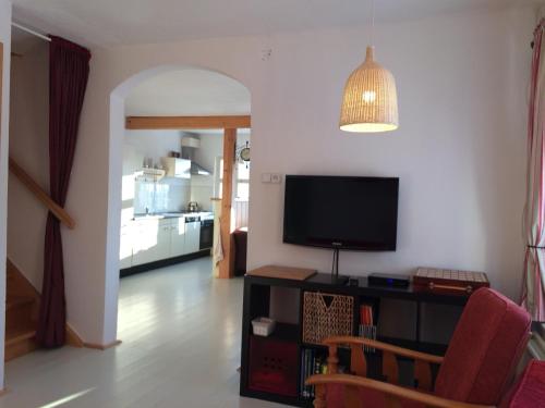 a living room with a flat screen tv on a table at Chata Hnyk in Zlatá Olešnice