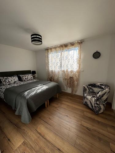 a bedroom with a bed and a chair and a window at Studio24 in Trélissac