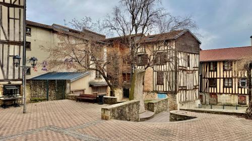 une cour vide avec des bâtiments anciens et un arbre dans l'établissement «Studio 1 » Rue Huchette -DABNB, à Limoges