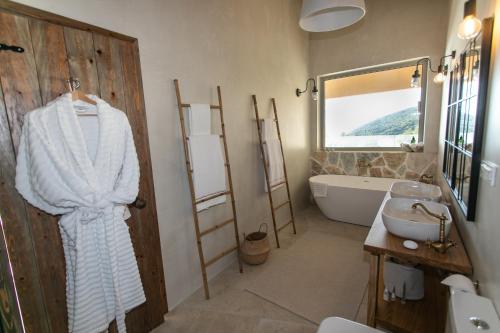 a bathroom with a bath tub and a sink and a mirror at Villa Elysium Parga in Parga