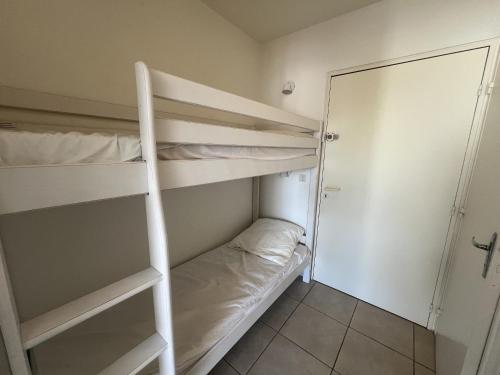 Cette chambre comprend 2 lits superposés et une porte. dans l'établissement Sol-y-Days, Résidence Thalassa en Première Ligne, à La Grande Motte