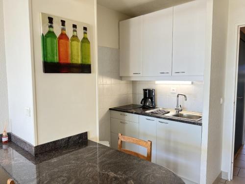 une cuisine avec des bouteilles sur le mur à côté d'un évier dans l'établissement Sol-y-Days Escale, appartement en premiere ligne face a la mer, à La Grande Motte