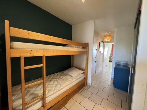 Ce lit superposé se trouve dans un dortoir doté d'un couloir. dans l'établissement Sol-y-Days Escale, appartement en premiere ligne face a la mer, à La Grande Motte