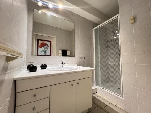 une salle de bain blanche avec un lavabo et une douche dans l'établissement Sol-y-Days Escale, appartement en premiere ligne face a la mer, à La Grande Motte
