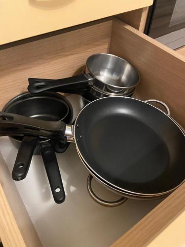 a frying pan and two pans in a drawer at 7 people - 1 price - Cozy attic apartment in Prešov