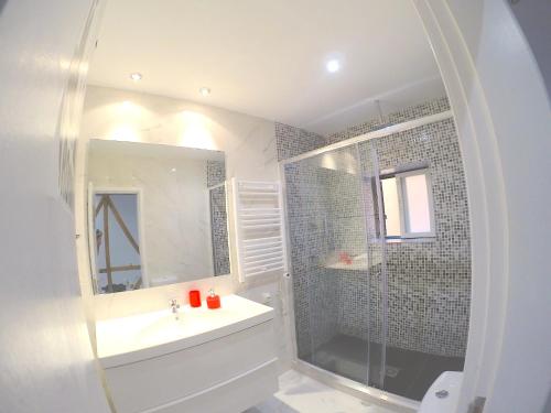a white bathroom with a sink and a shower at Sao Paulo Apartment in Lisbon