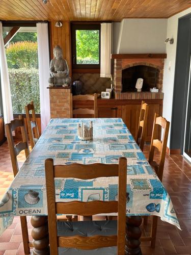 une salle à manger avec une table, des chaises et une cheminée dans l'établissement Bassin d'Arcachon 3 chamb jardin, villa conviviale, à La Teste-de-Buch