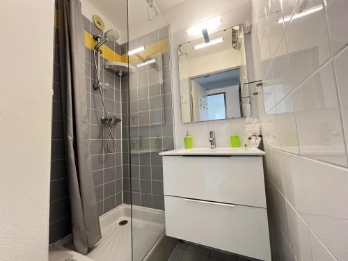 une salle de bain avec un lavabo et une douche dans l'établissement Sol-y-Days Bali, agréable appartement à vivre, à La Grande Motte