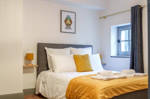 - une chambre dotée d'un lit avec des draps blancs et orange dans l'établissement Le Grand Colbert - By PrestiPlace, à Tours