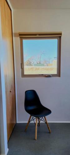 a black chair sitting in front of a window at Chic Townhome Haven rooted Downtown in Albuquerque