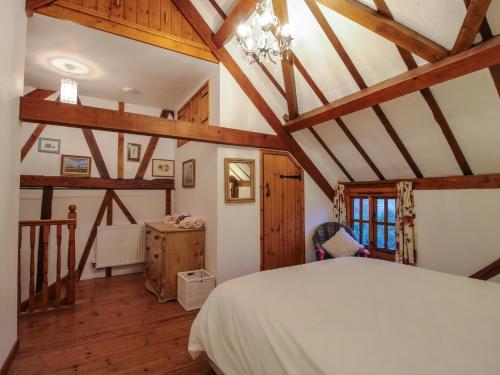 a bedroom with a bed and wooden ceilings at Tawny Owl Barn in Craven Arms
