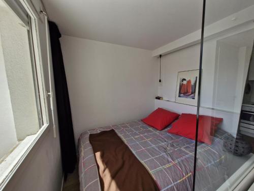 - une petite chambre avec un lit et des oreillers rouges dans l'établissement Sol-y-Days Hermes, grande terrasse au calme 5 mn des plages, à La Grande Motte