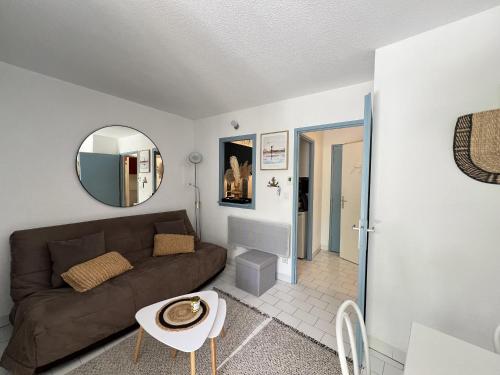 - un salon avec un canapé brun et un miroir dans l'établissement Sol-y-Days Tropic, rez de jardin avec terrasse, à La Grande Motte