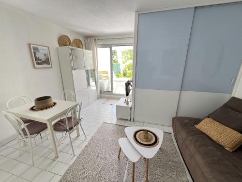 un salon avec un canapé et une table dans l'établissement Sol-y-Days Tropic, rez de jardin avec terrasse, à La Grande Motte