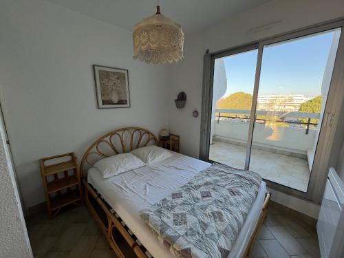 une chambre avec un lit et une grande fenêtre dans l'établissement Sol-y-Days Escale Belle vue mer, à La Grande Motte