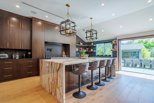 an open kitchen with a large island with bar stools at Modern luxury house pool enormous yard in Los Angeles