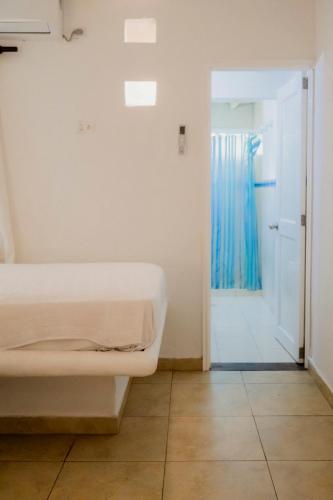 a bedroom with a bed and a door with a blue curtain at Isla Amor in Cartagena de Indias