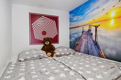 a teddy bear sitting on a bed in a bedroom at Ferienhaus Zeulenrodaer Meer in Stelzendorf