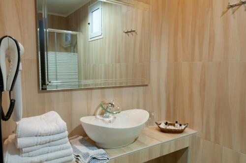 a bathroom with a white sink and a mirror at Metropolis Hotel in Serres