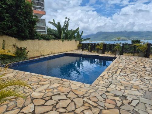 a swimming pool in the middle of a stone walkway at Residencial Azul Marinho - Suítes por temporada in Ilhabela