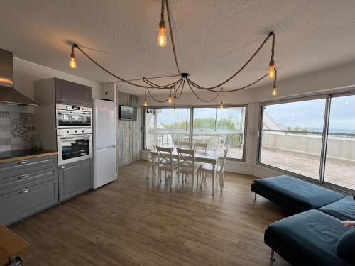 une cuisine et une salle à manger avec une table et des chaises dans l'établissement Sol-y-Days Ulysse Plages, terrasse panoramique avec vue sur mer, à La Grande Motte