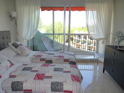 une chambre avec un lit et un balcon dans l'établissement Sol-y-Days Eden, Magnifique appartement de deux chambres, en duplex face a la mer et au port de plaisance, à La Grande Motte