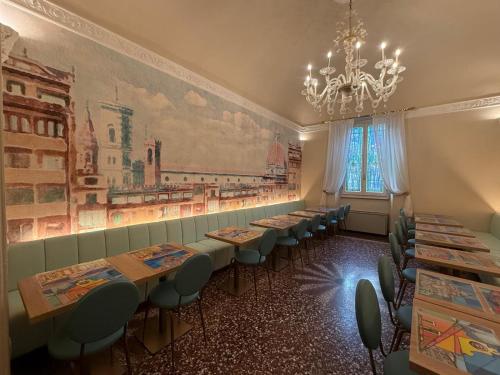 a row of tables in a restaurant with a chandelier at Hotel Donatello in Florence