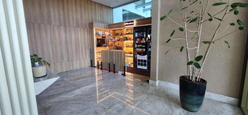a store lobby with a potted tree in a vase at Parque do Cais - Flats Premium no Recife por Yolo in Recife