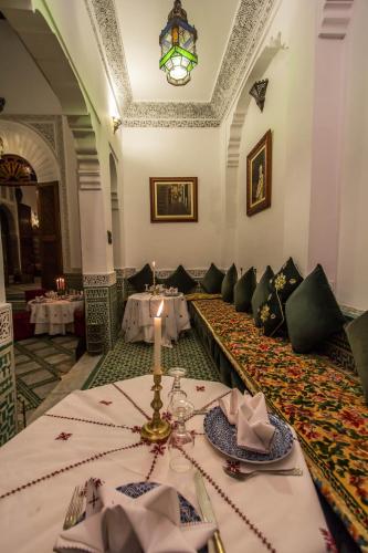 a dining room with a table with a candle on it at Riad - Dar Al Andalous in Fès