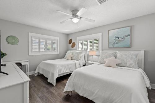 a bedroom with two beds and a ceiling fan at Blue Tide Hideaway - Golf Cart, Sznl Hot Tub, Pets OK, FREE Daily Activities, & More! in Panama City
